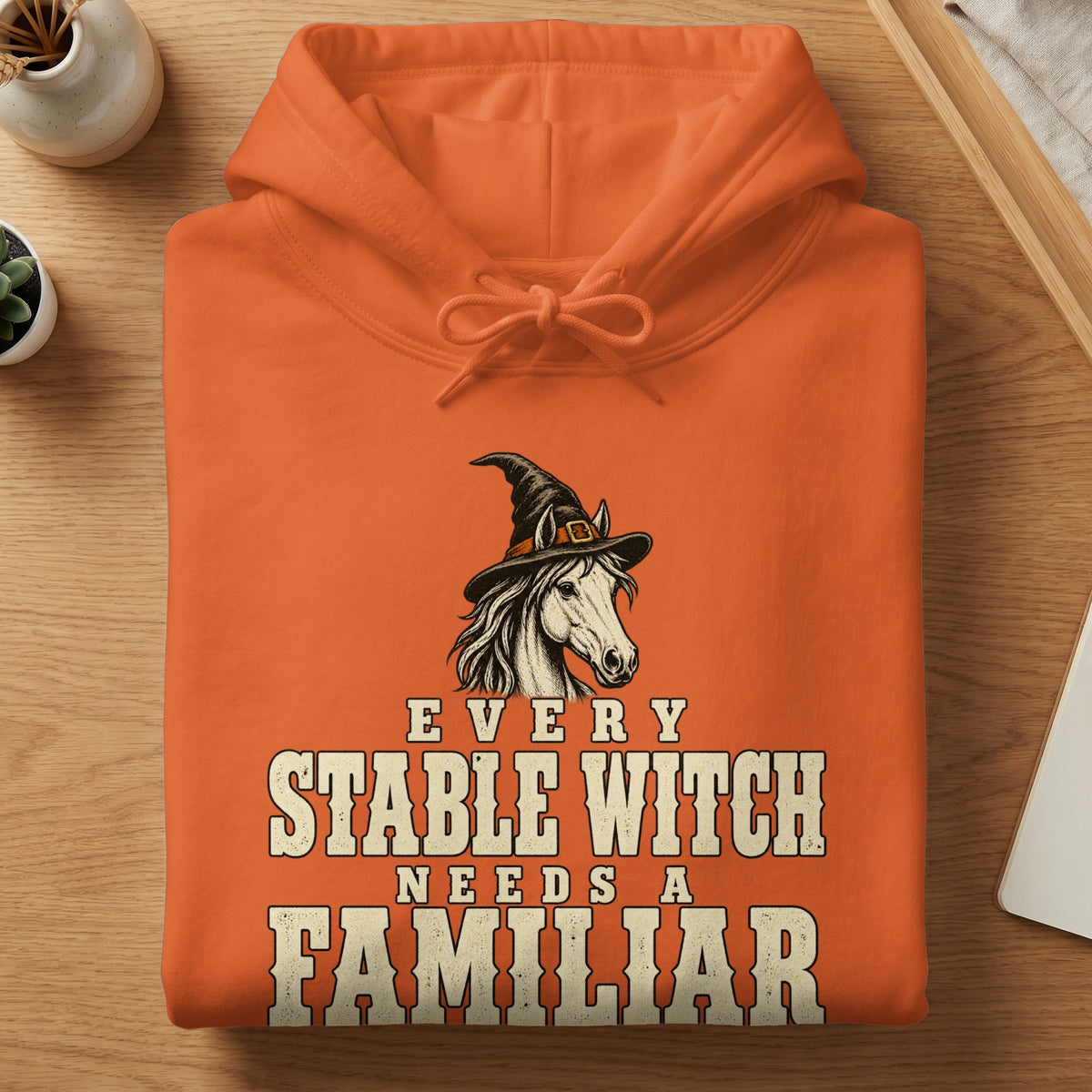 Orange hoodie with a horse wearing a witch hat and the text "EVERY STABLE WITCH NEEDS A FAMILIAR".
