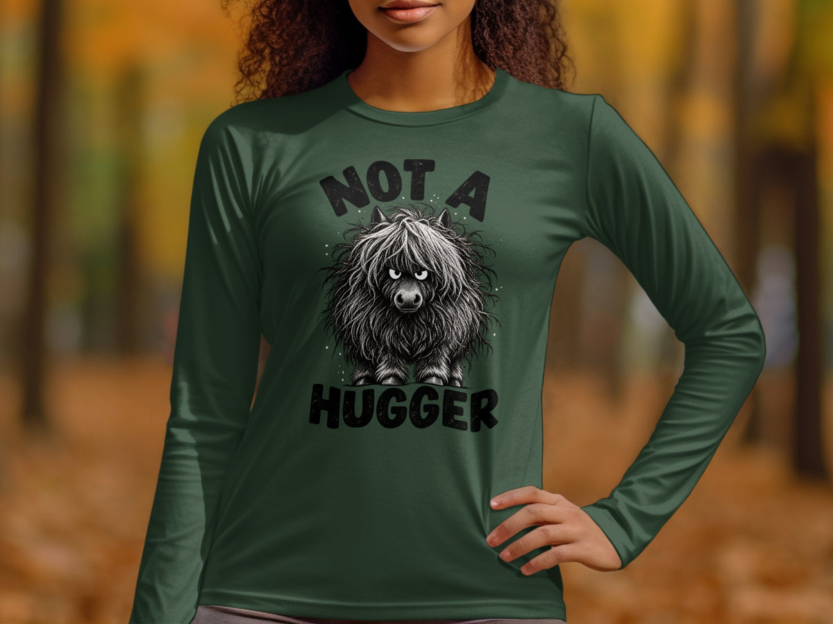 Green long-sleeved shirt with a shaggy, grumpy Highland cow graphic and text "NOT A HUGGER".