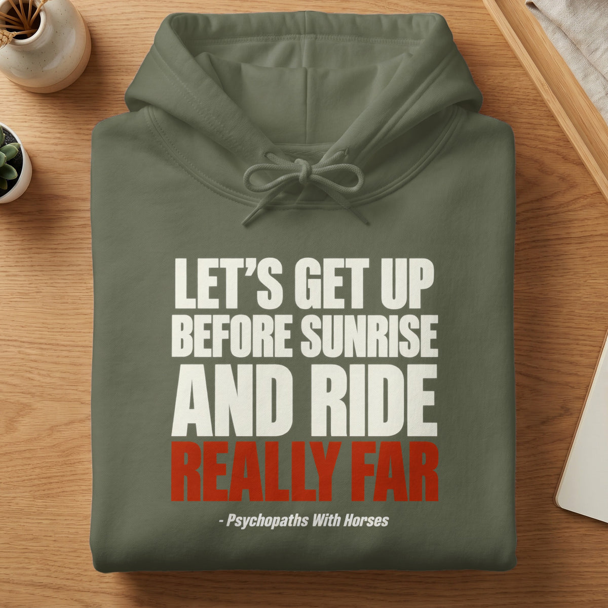An olive green hoodie printed with the white and red text, LET’S GET UP BEFORE SUNRISE AND RIDE REALLY FAR - Psychopaths With Horses.