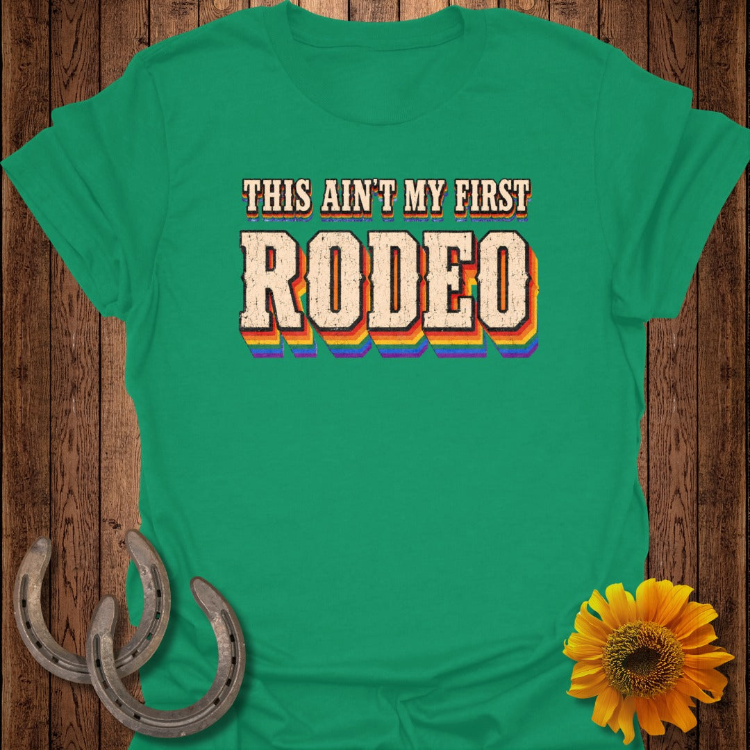 Green t-shirt with "This Ain't My First Rodeo" in rainbow lettering.