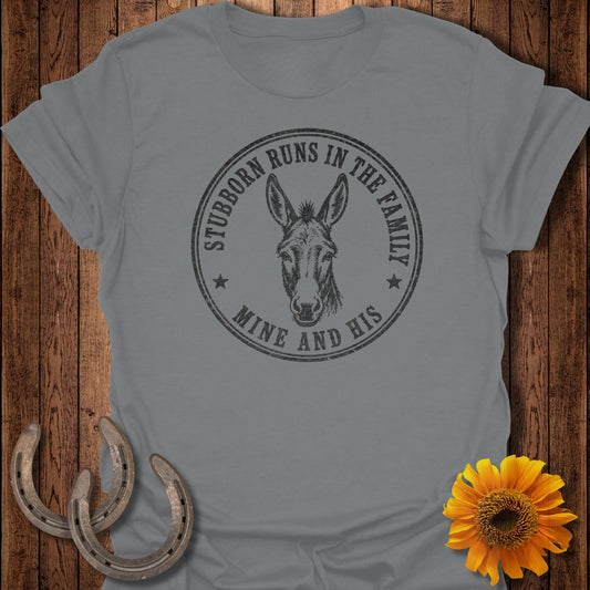 Grey t-shirt with circular graphic of donkey head and text "Stubborn Runs in the Family Mine and His".