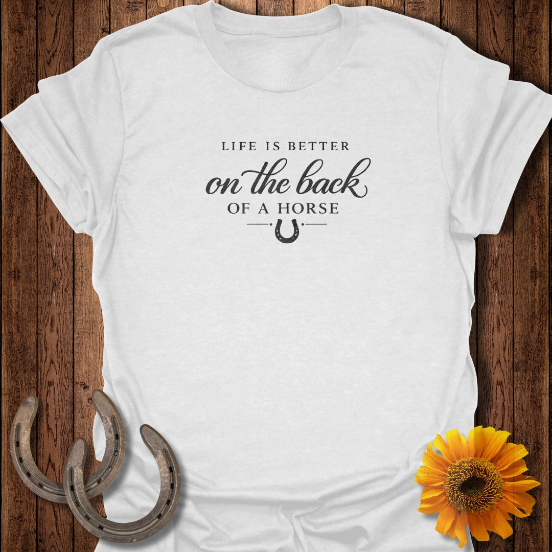 White t-shirt with "Life is better on the back of a horse" text and horseshoe.