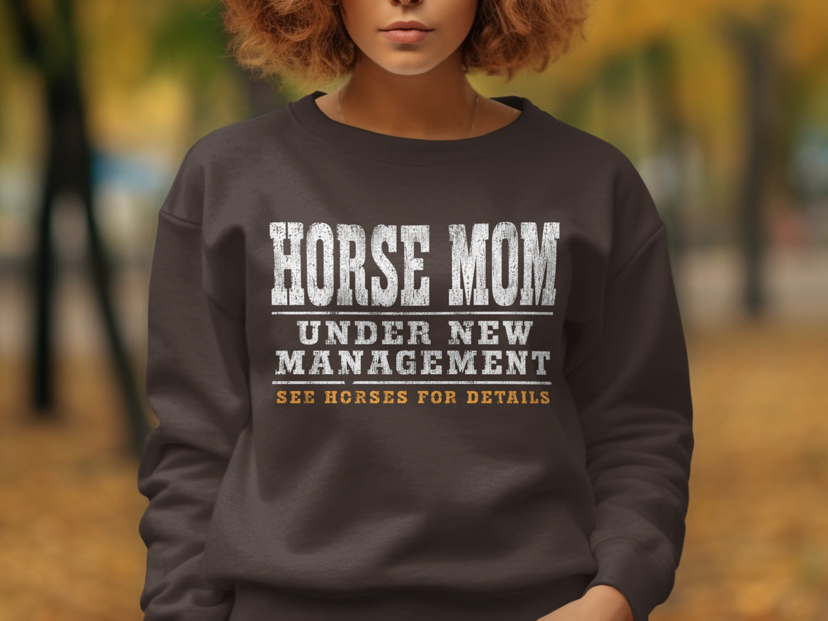 Brown sweatshirt with white text: HORSE MOM UNDER NEW MANAGEMENT SEE HORSES FOR DETAILS