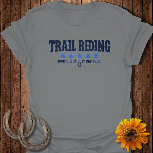 A grey t-shirt with text that reads Trail Riding, five blue stars, and a horseshoe.
