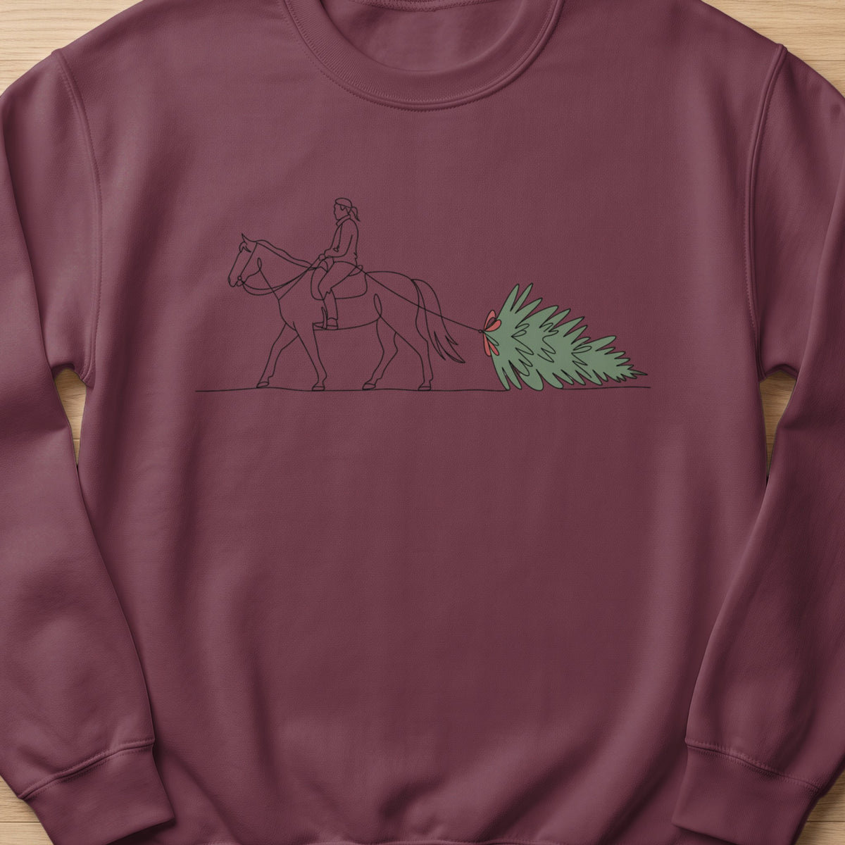 Line drawing of a person riding a horse, pulling a Christmas tree tied with a ribbon.