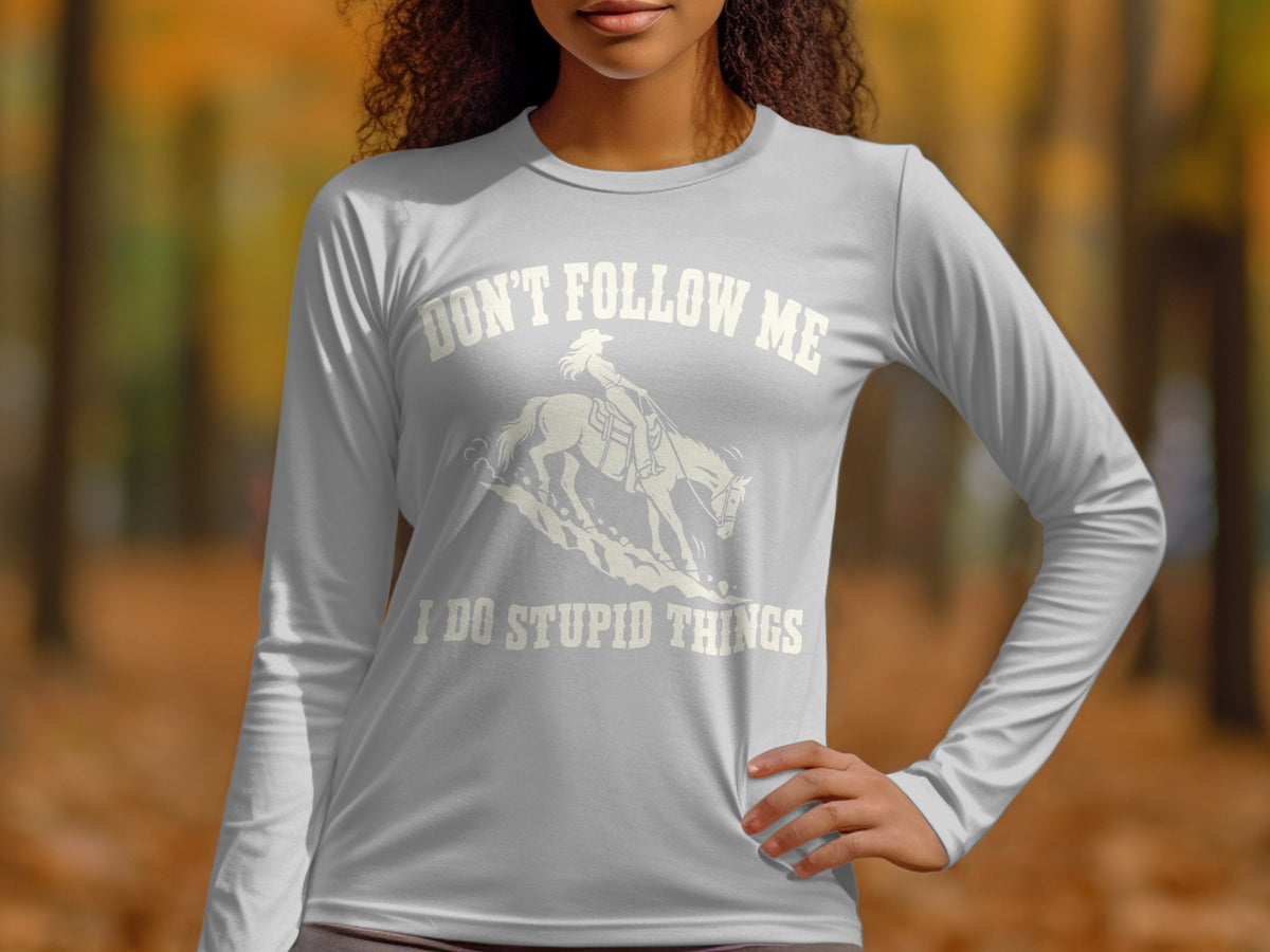 A person wearing a light gray long-sleeve shirt with white text and a graphic of a horse and rider.