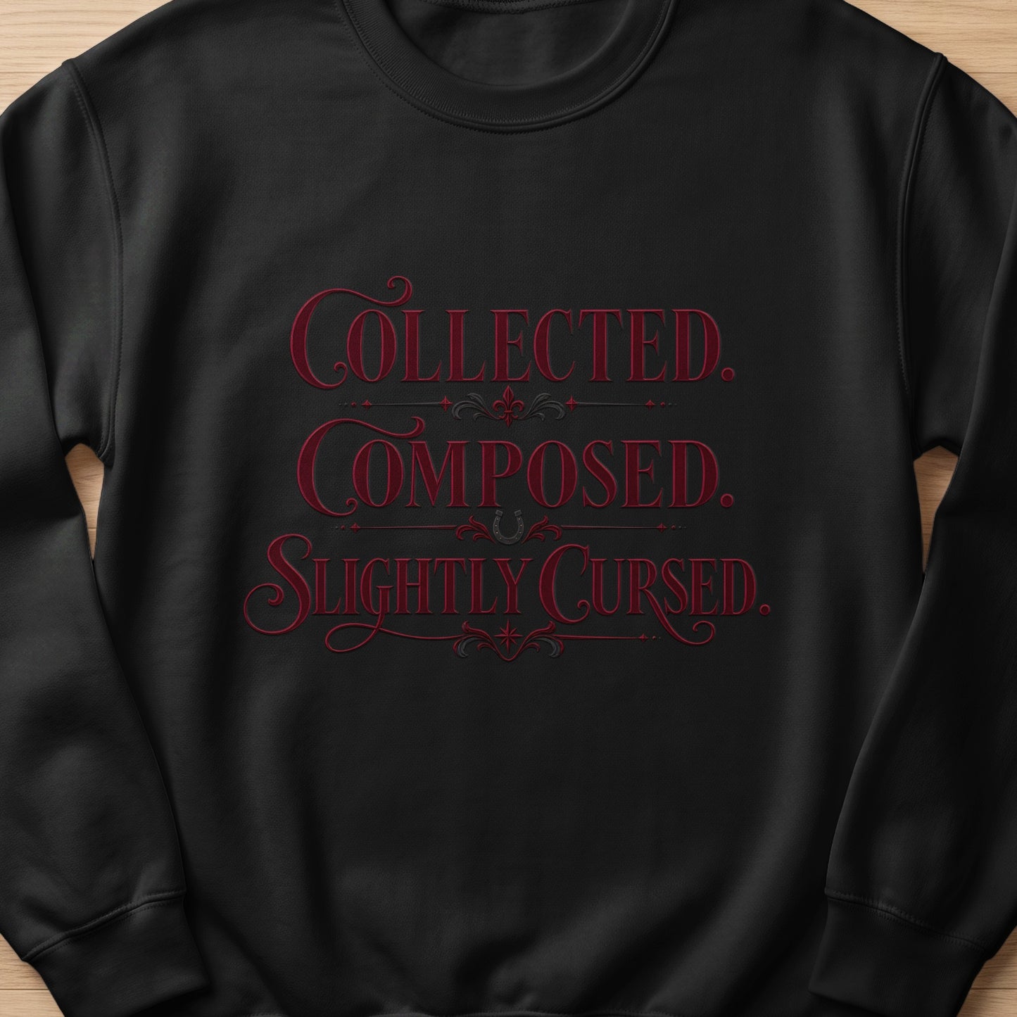 Black sweatshirt with red text "COLLECTED. COMPOSED. SLIGHTLY CURSED."