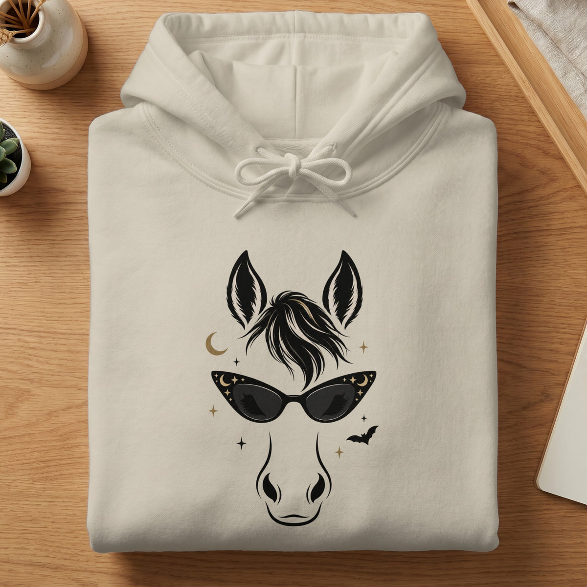 Cream hoodie with a black illustrated horse head wearing sunglasses and celestial details.