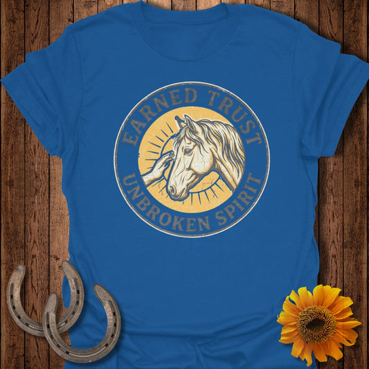 Blue t-shirt with circular logo featuring a horse and hand, text "EARNED TRUST UNBROKEN SPIRIT."