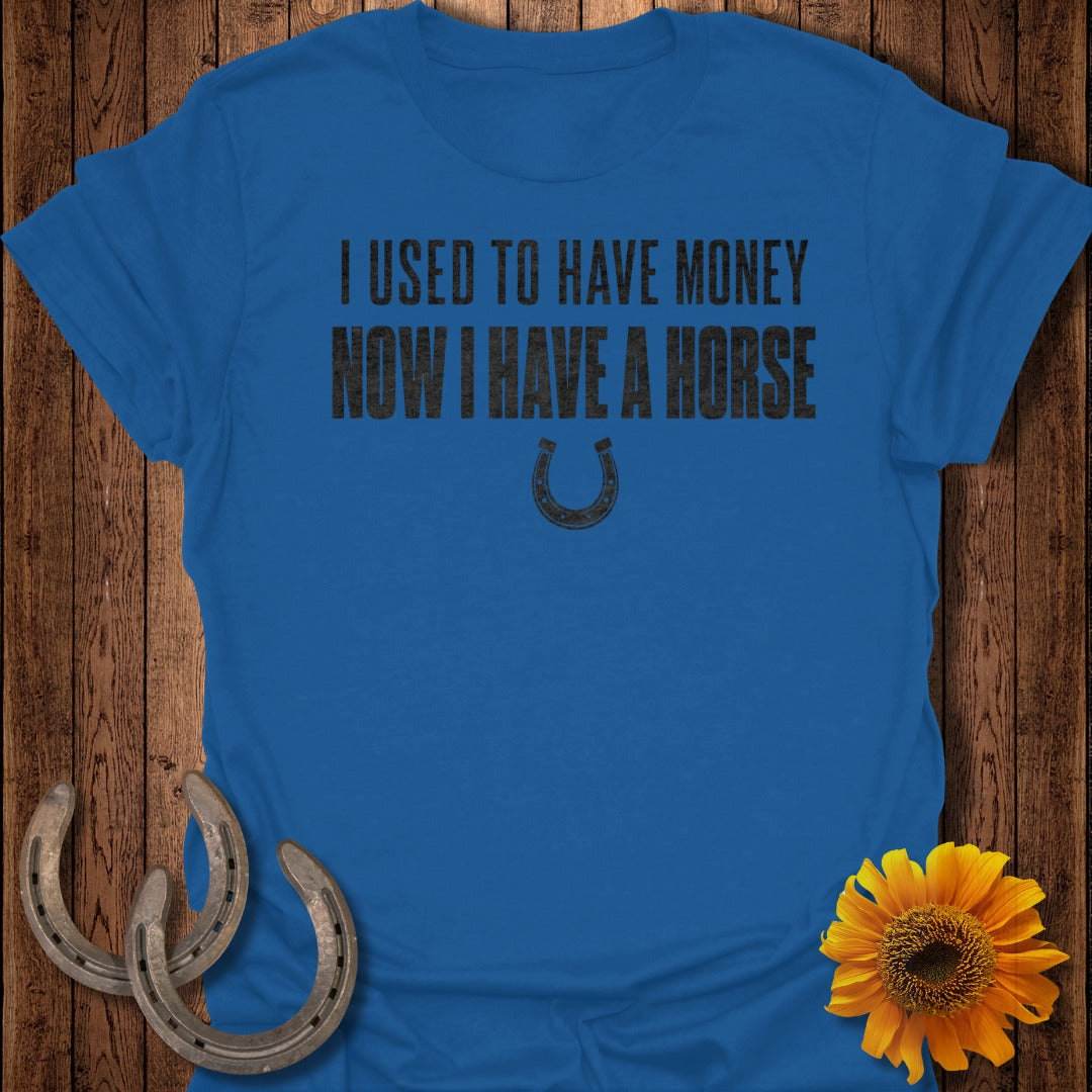 Blue t-shirt with text "I used to have money, now I have a horse" and horseshoe graphic.