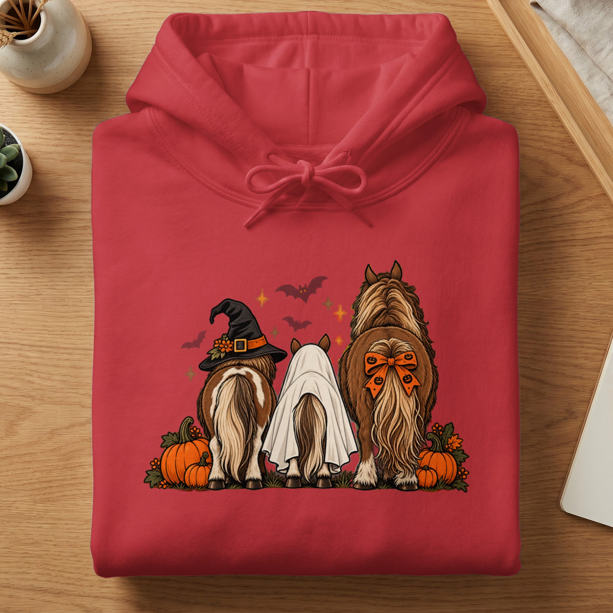 Three horses in Halloween costumes - witch hat, ghost, and pumpkin bow - with pumpkins.