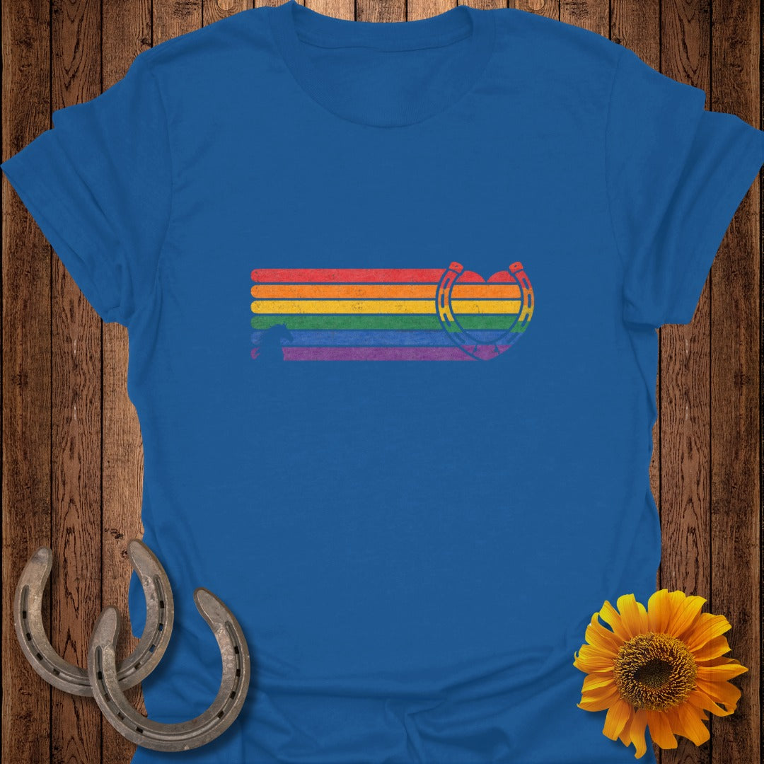 Rainbow striped horseshoe with heart detail on a blue t-shirt.