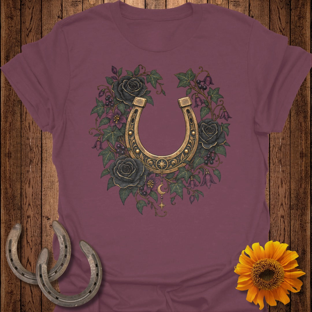 Burgundy t-shirt with golden horseshoe surrounded by dark roses and greenery.