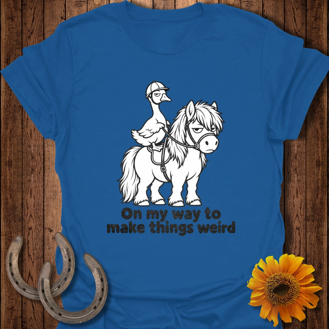 A blue t-shirt featuring a duck wearing a helmet riding a pony, with text reading On my way to make things weird.
