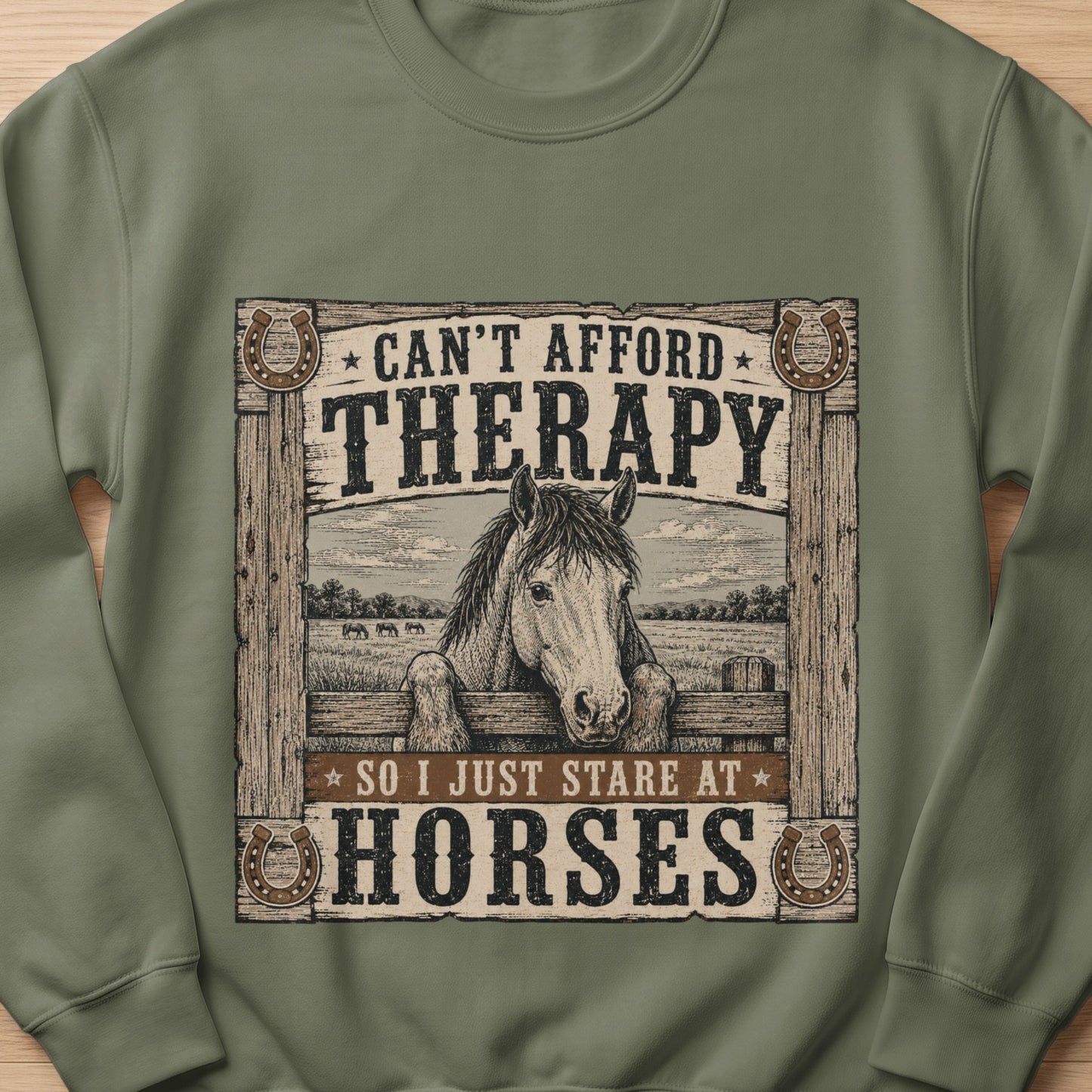 Green sweatshirt with horses, fence, and text: "Can't afford therapy so I just stare at horses."