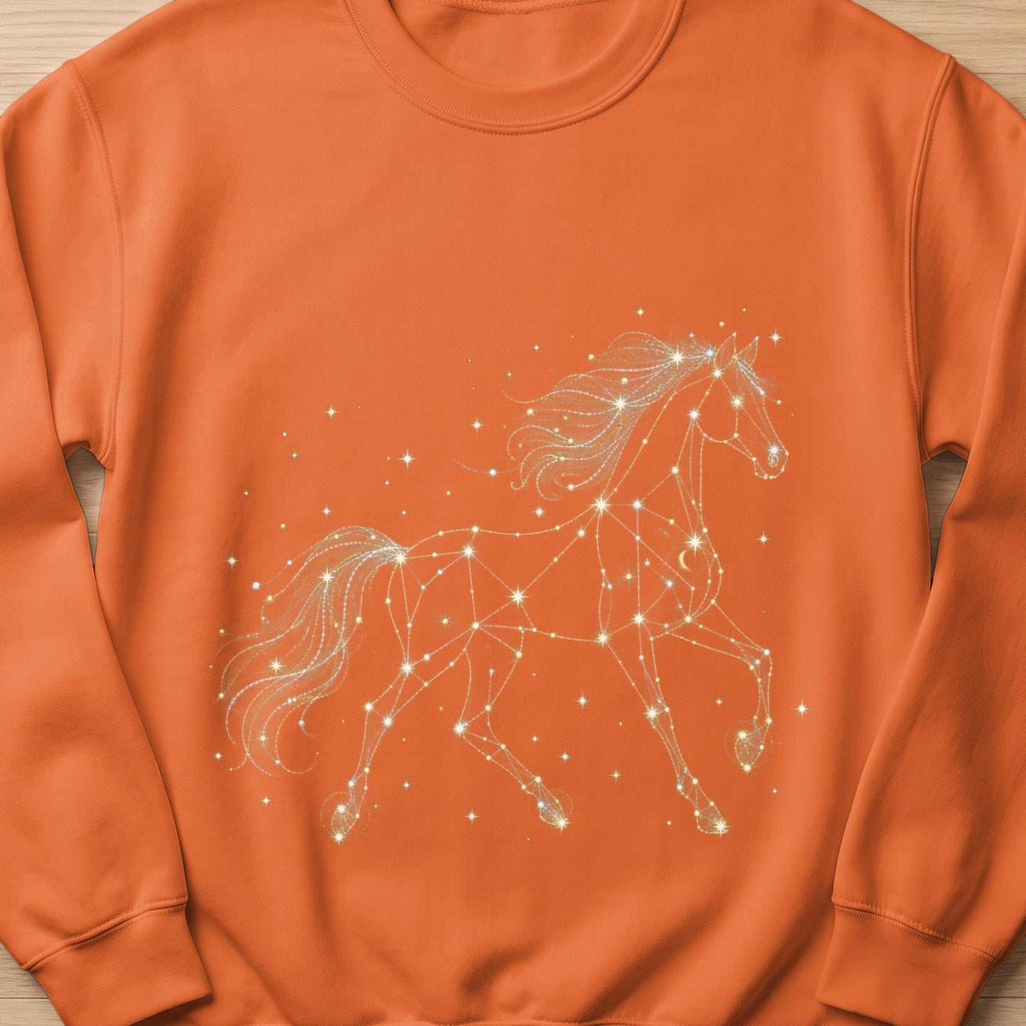 Orange sweatshirt with a white constellation horse graphic and scattered stars.