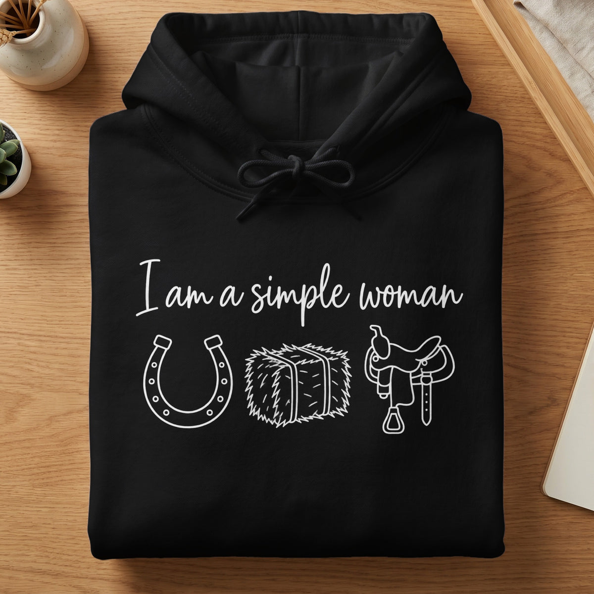 Black hoodie with white text "I am a simple woman" and icons of horseshoe, hay bale, saddle.
