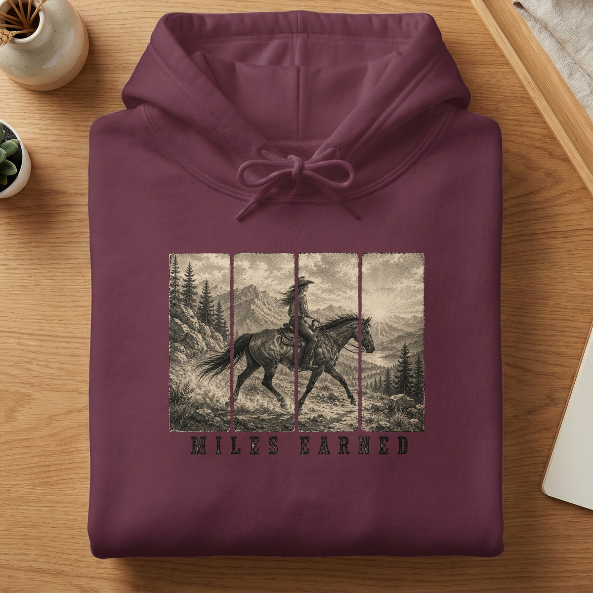 Burgundy hoodie with "Miles Earned" text and a vintage graphic of a woman riding a horse.