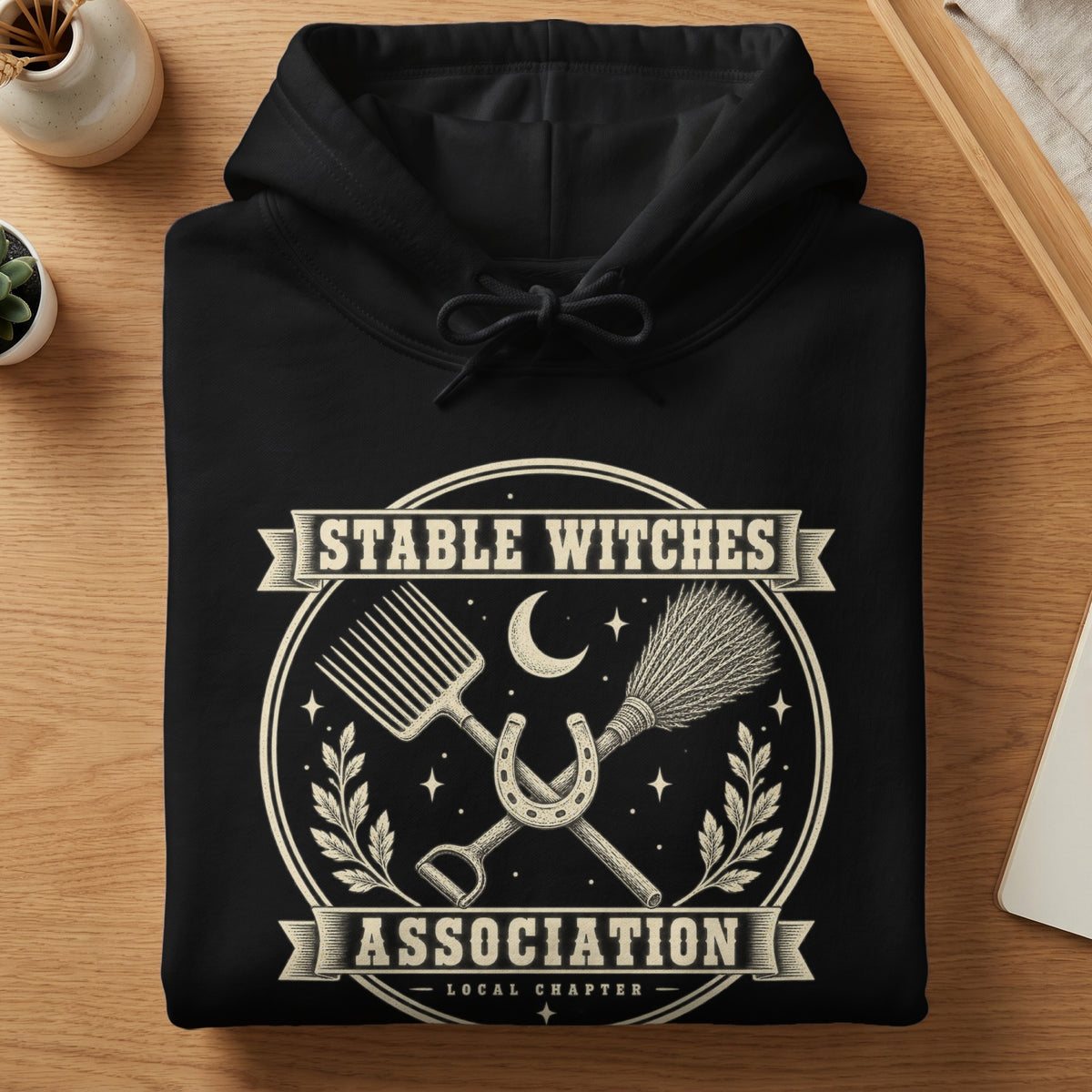 Black hoodie with "Stable Witches Association Local Chapter" text and witchy barn graphics.