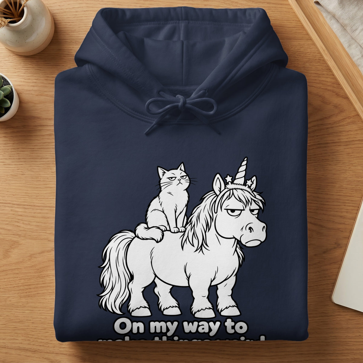 Dark navy hoodie with a print of a grumpy cat riding a grumpy unicorn, with text "On my way to".