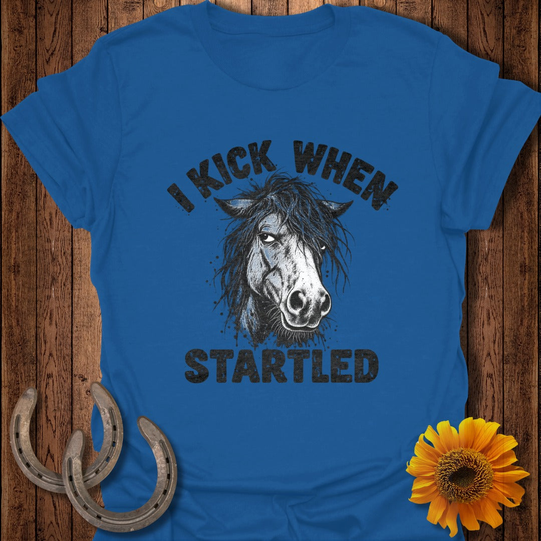 A blue t-shirt featuring a graphic of a horse and the text I KICK WHEN STARTLED.