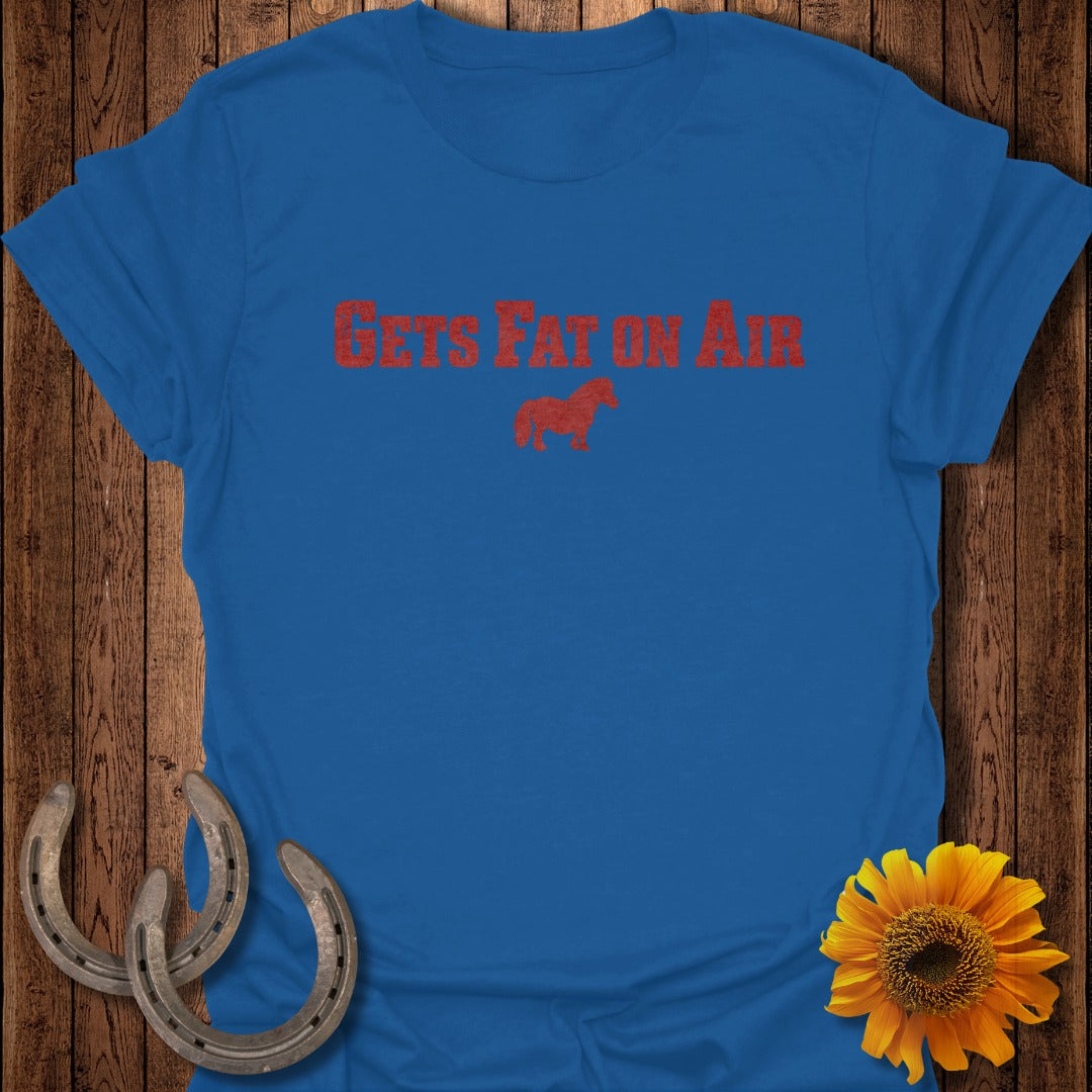 Blue t-shirt with distressed red text "GETS FAT ON AIR" and a horse graphic.