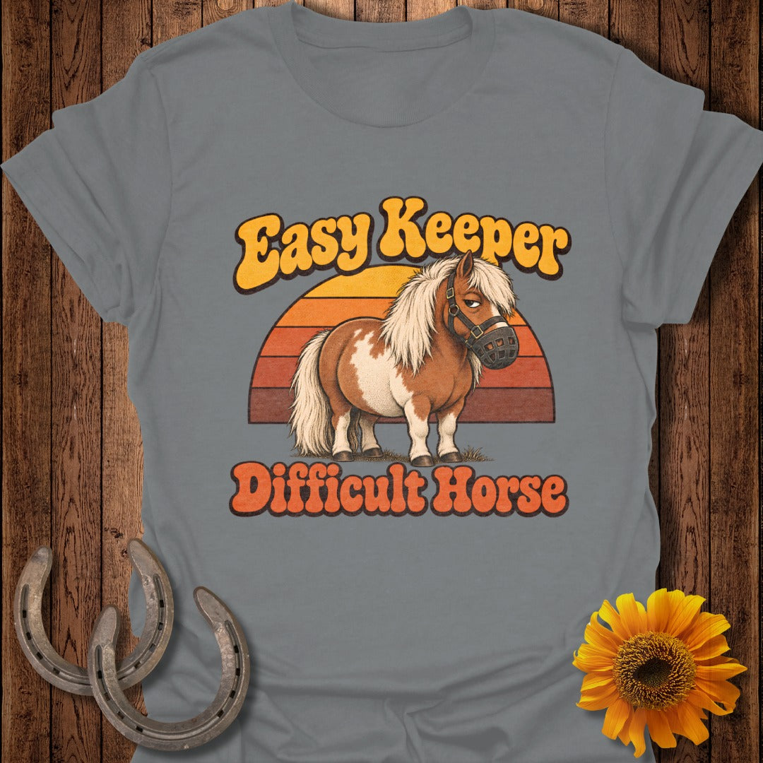 Brown and white pony wearing a muzzle with text "Easy Keeper Difficult Horse".