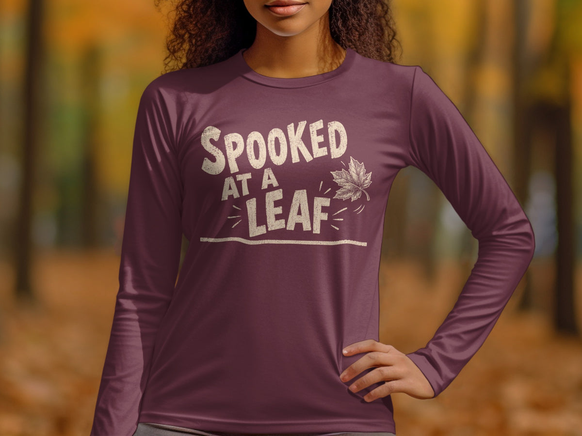 Maroon long sleeve shirt with "Spooked at a Leaf" text and autumn leaf graphic.