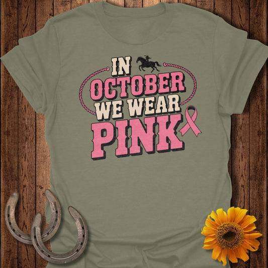 Olive green t-shirt with text "In October We Wear Pink" and a pink ribbon.