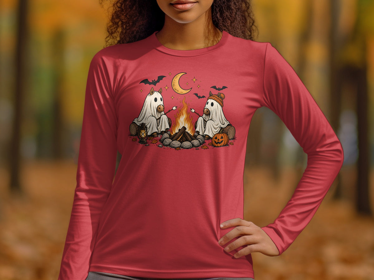 Two horses in ghost costumes roast marshmallows by a campfire under a crescent moon.