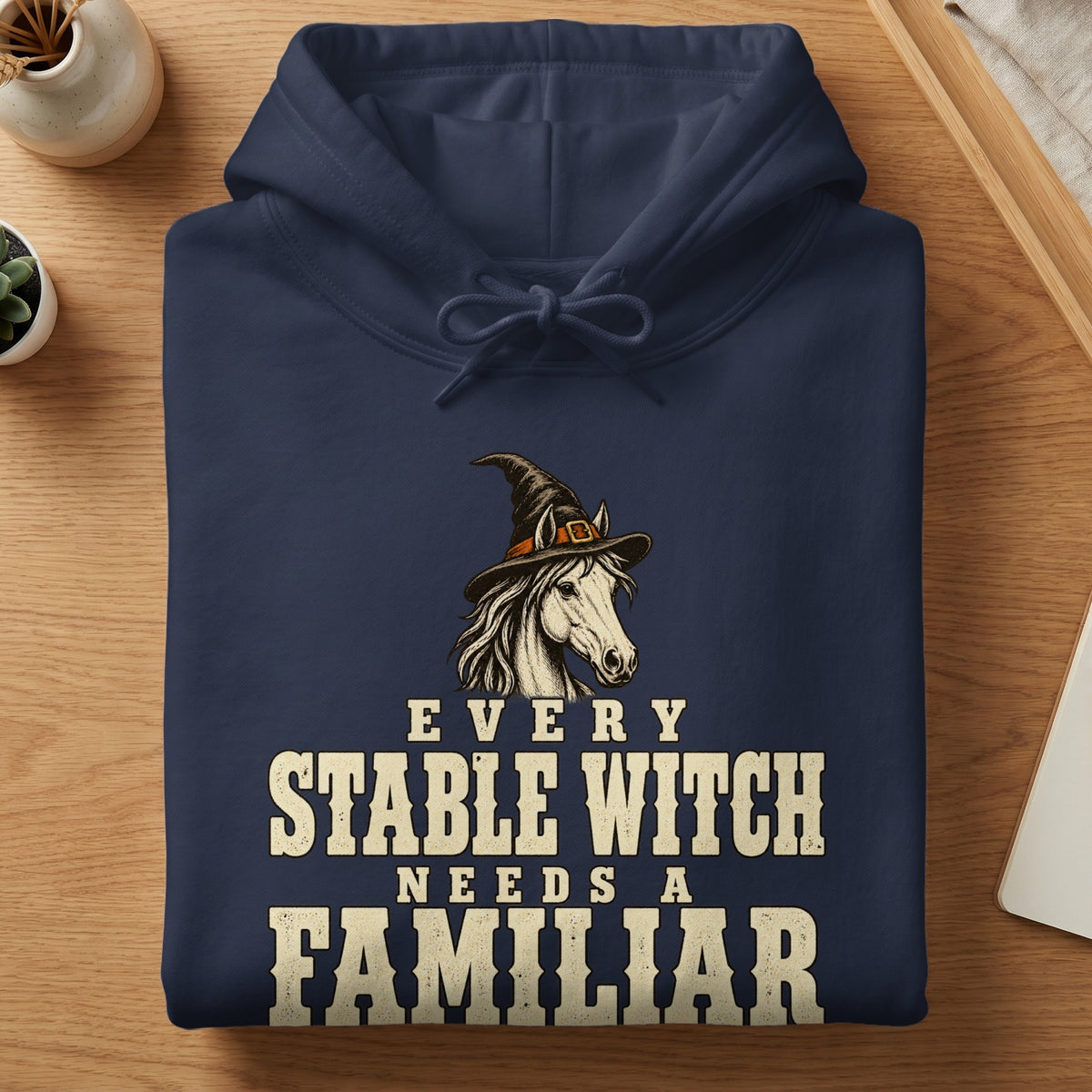 Dark blue hoodie with witch hat horse graphic and text "EVERY STABLE WITCH NEEDS A FAMILIAR".