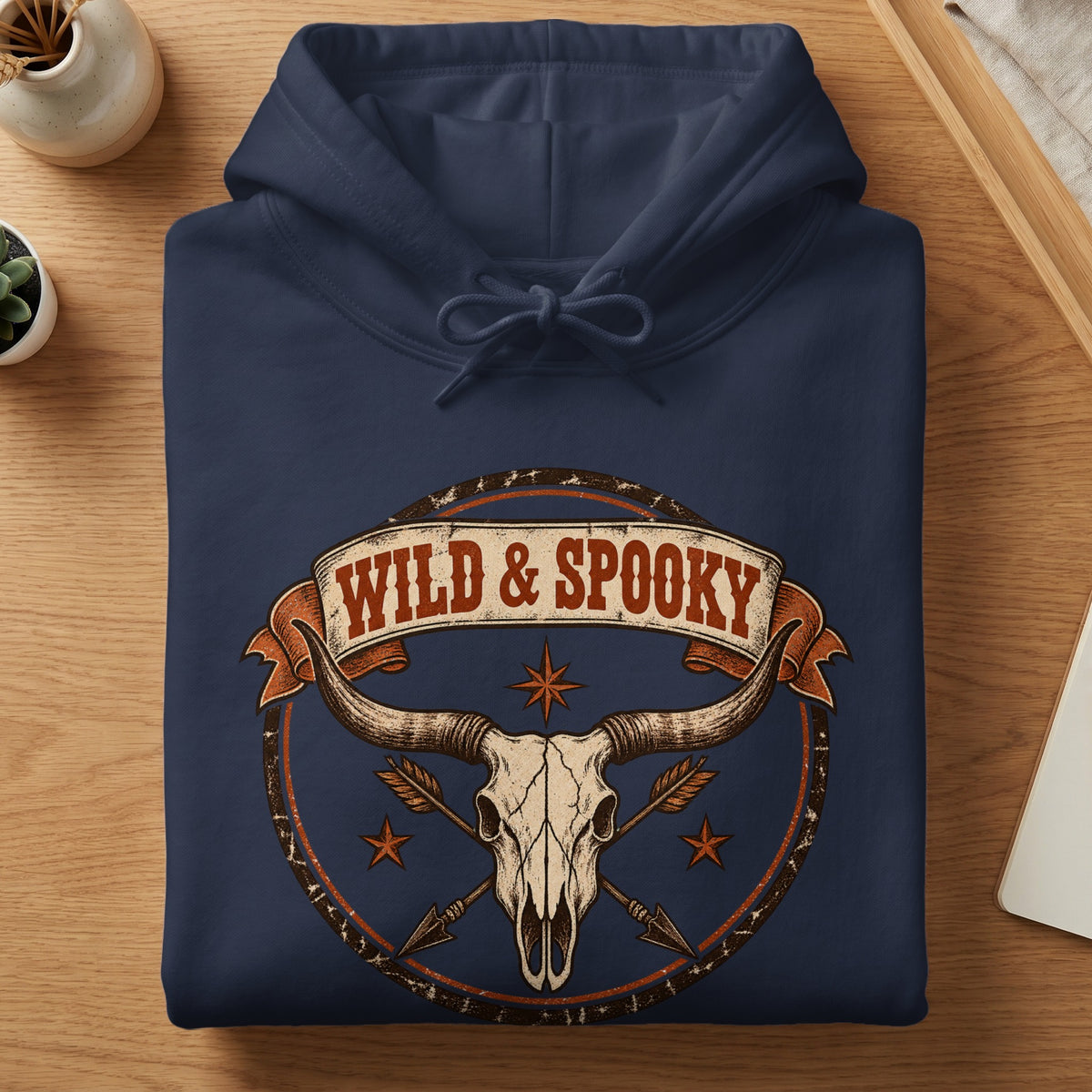 Navy blue hoodie with a longhorn skull, arrows, and "WILD & SPOOKY" text.