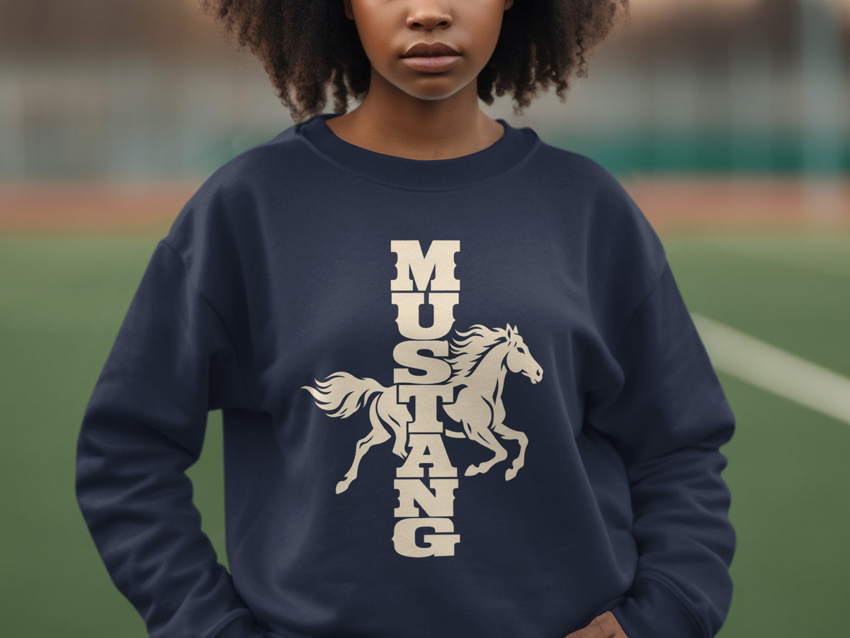 A person wearing a dark blue crewneck sweatshirt with a vertical cream-colored mustang graphic.