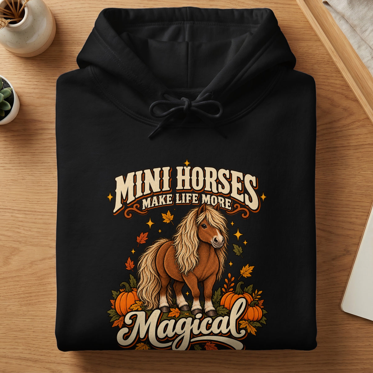 Black hoodie with "Mini Horses Make Life More Magical" text and autumn horse graphic.