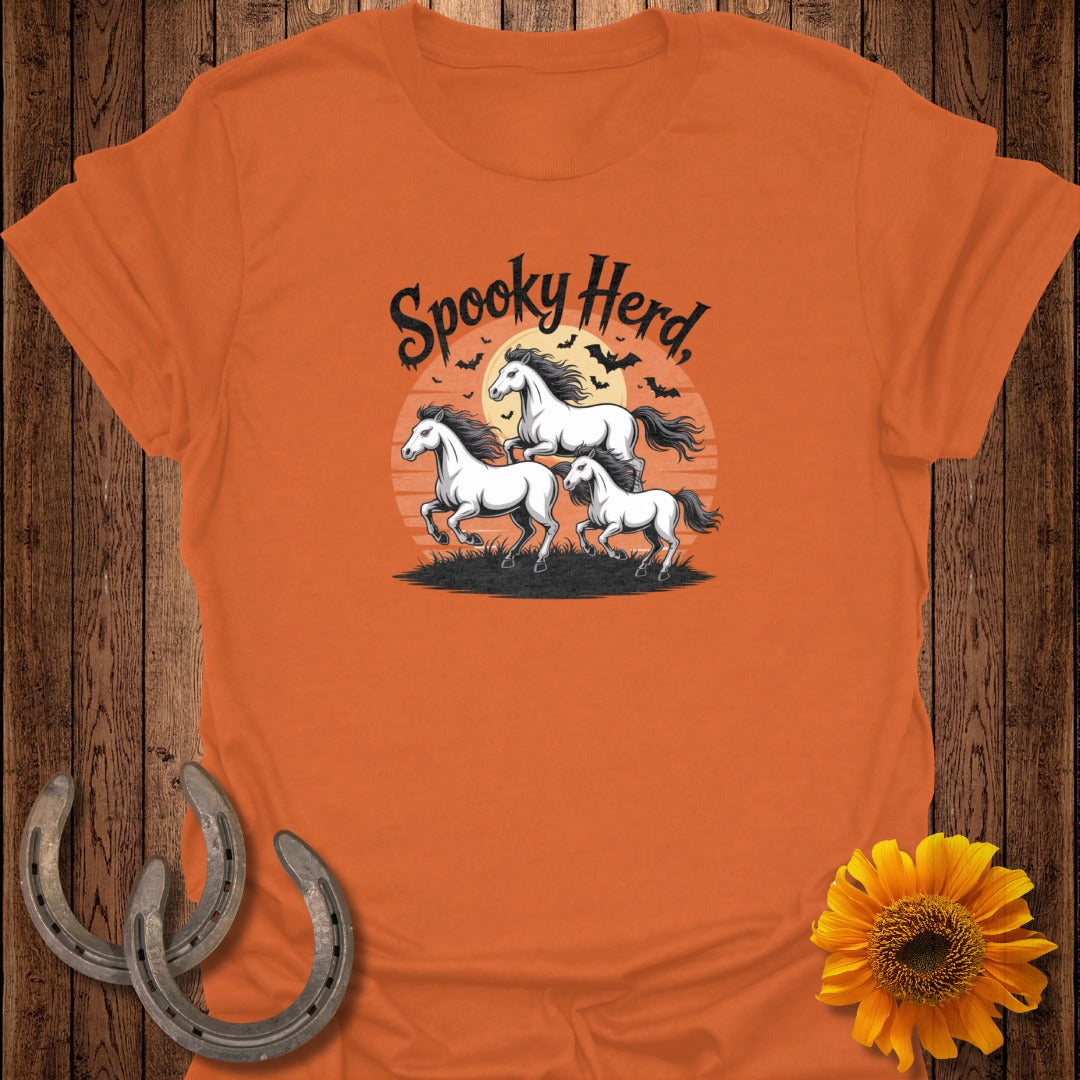 Orange t-shirt with "Spooky Herd" text and three horses with bats at sunset.