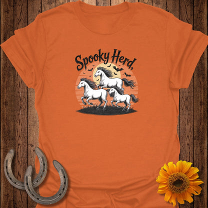 Orange t-shirt with "Spooky Herd" text and three horses with bats at sunset.