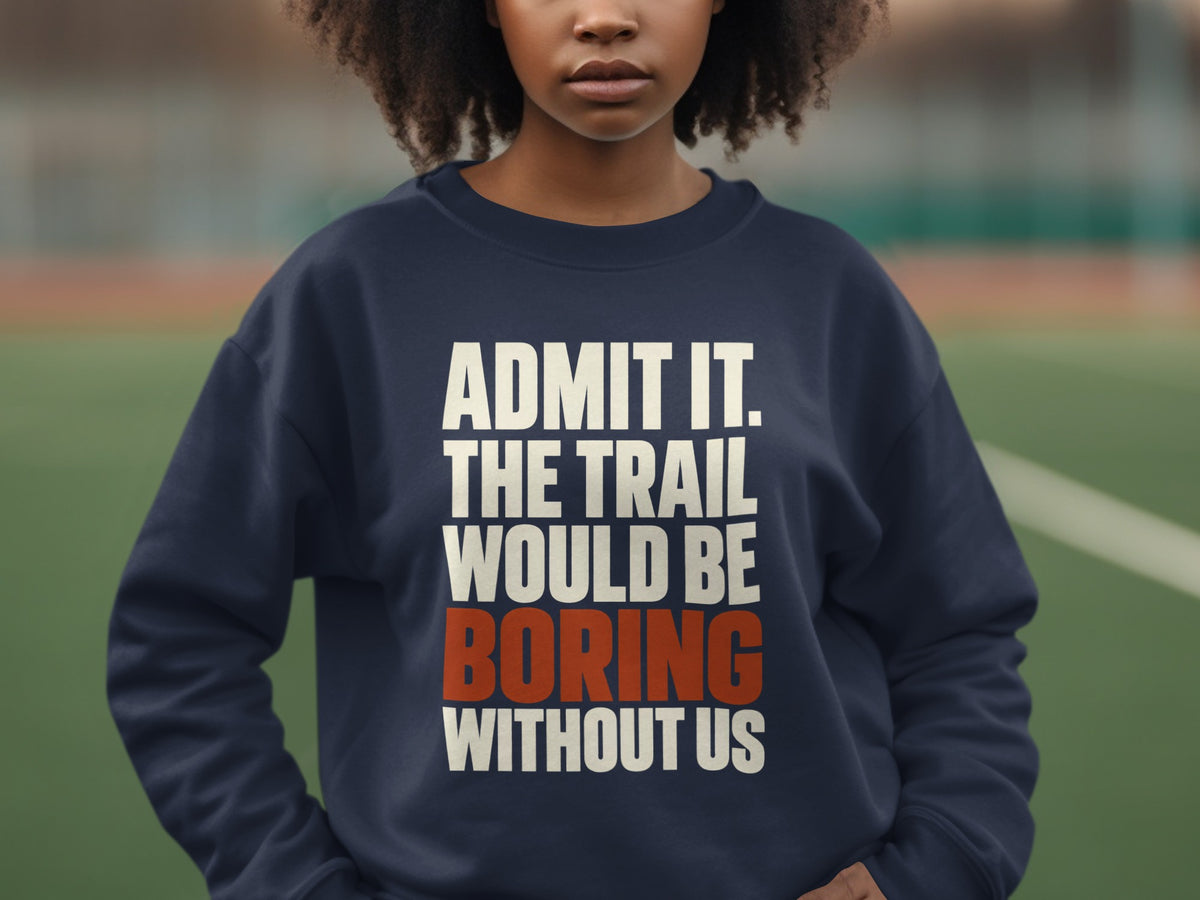 A person wearing a dark blue crewneck sweatshirt with the text "ADMIT IT. THE TRAIL WOULD BE BORING WITHOUT US" printed across the chest.