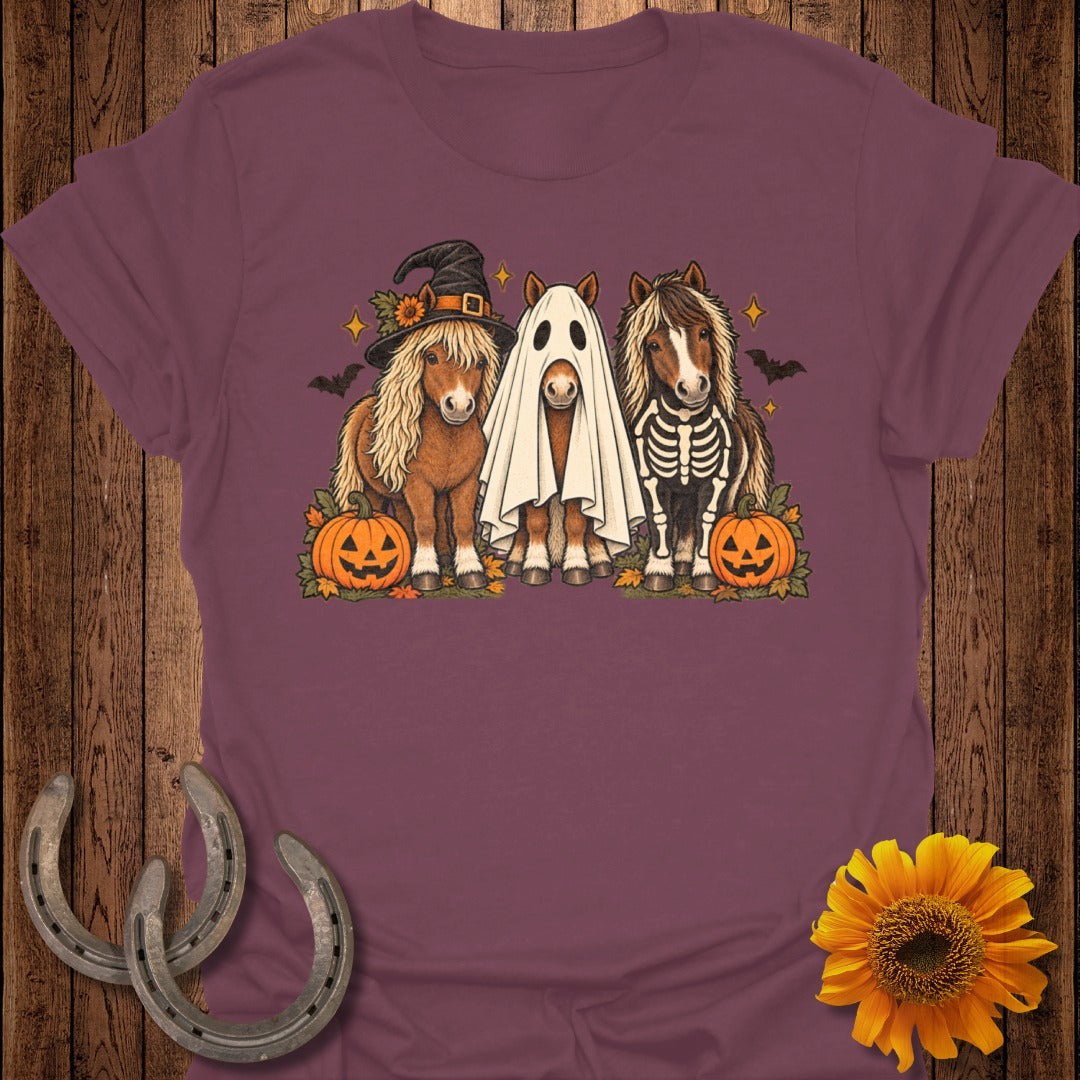 Three horses in Halloween costumes: witch hat, ghost, and skeleton, with pumpkins.