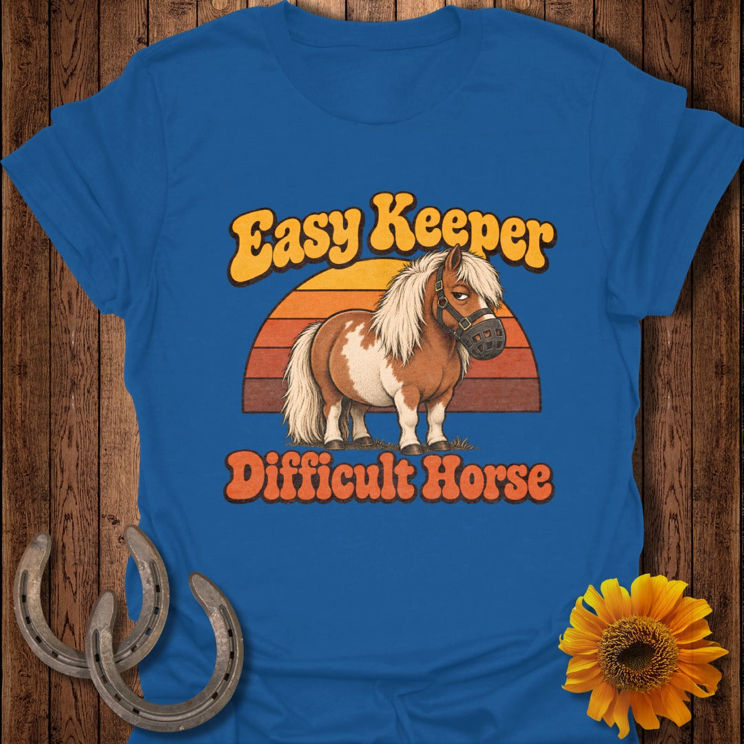 Cartoon pony wearing a muzzle with text "Easy Keeper Difficult Horse".