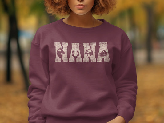 Maroon sweatshirt with "NANA" text and horse, horseshoe, helmet, and brush graphics.