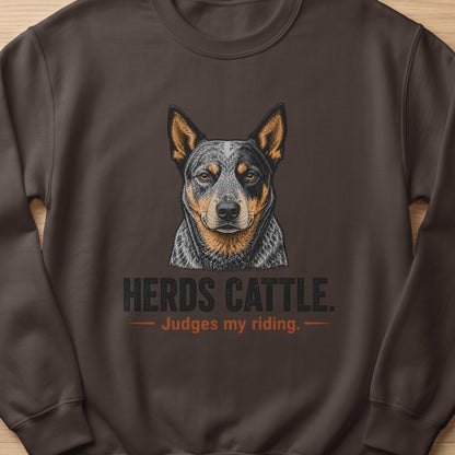 Brown sweatshirt with a drawing of an Australian Cattle Dog and text "Herds Cattle. Judges my riding."