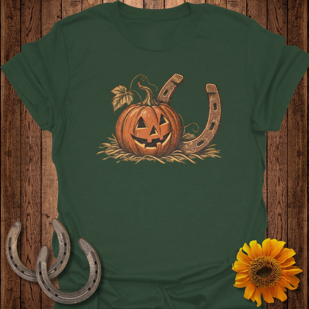 Jack-o'-lantern pumpkin and two horseshoes on straw with autumn leaves.