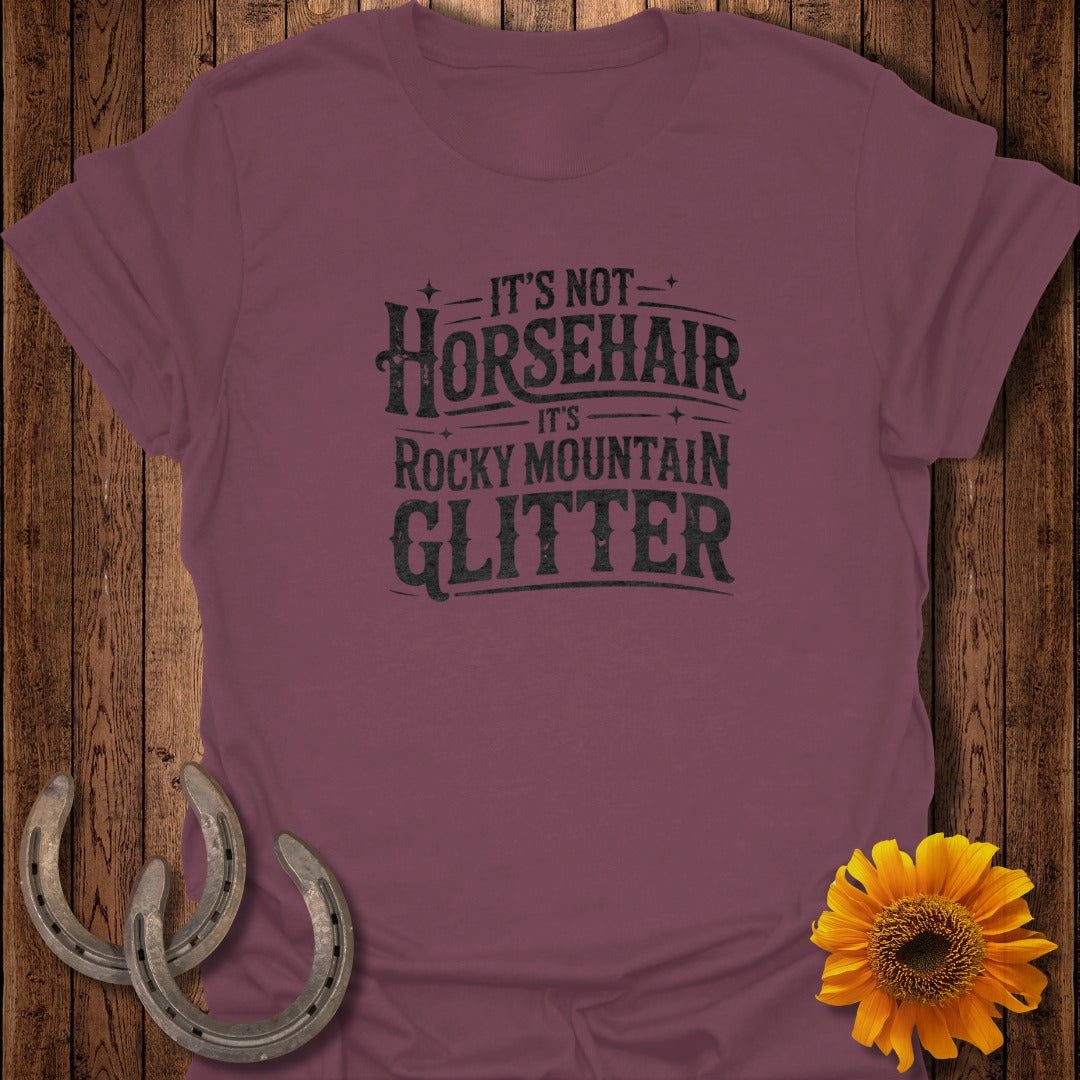 Maroon t-shirt with "It's not horsehair, it's Rocky Mountain glitter" text.