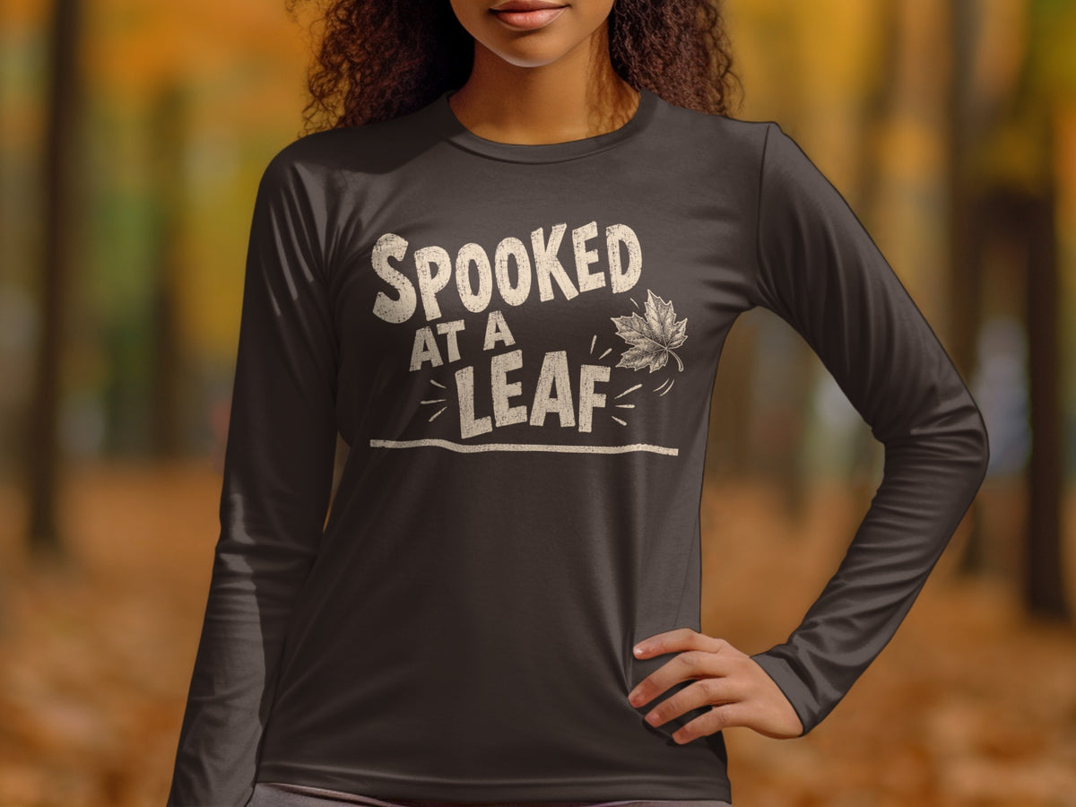 Dark long-sleeve shirt with "Spooked At A Leaf" text and a maple leaf graphic.
