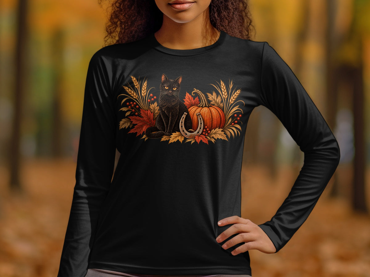 Black cat, pumpkin, horseshoe, and fall leaves graphic on a black long-sleeved shirt.