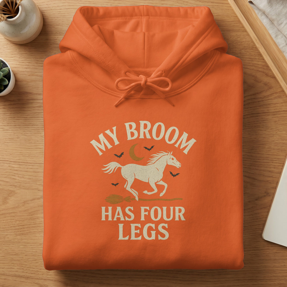 Orange hoodie with "My Broom Has Four Legs" text and horse graphic.