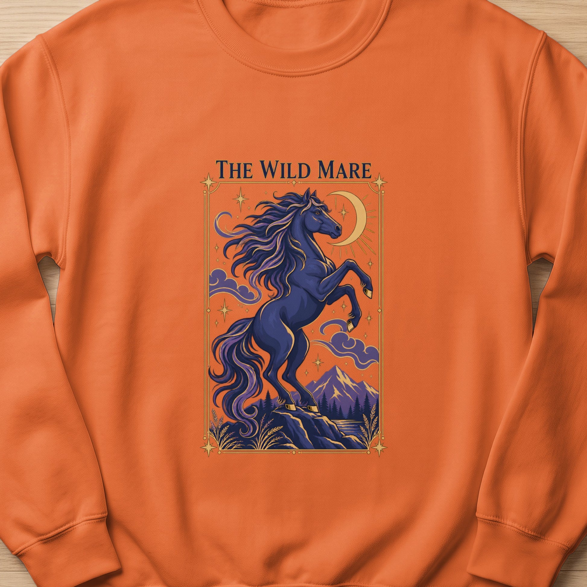 The Wild Mare text above dark blue horse rearing on rocks under crescent moon and starry sky.