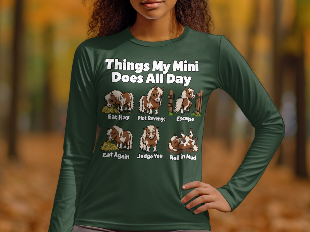 A person wearing a dark green long-sleeved shirt with a graphic about miniature horse daily activities.