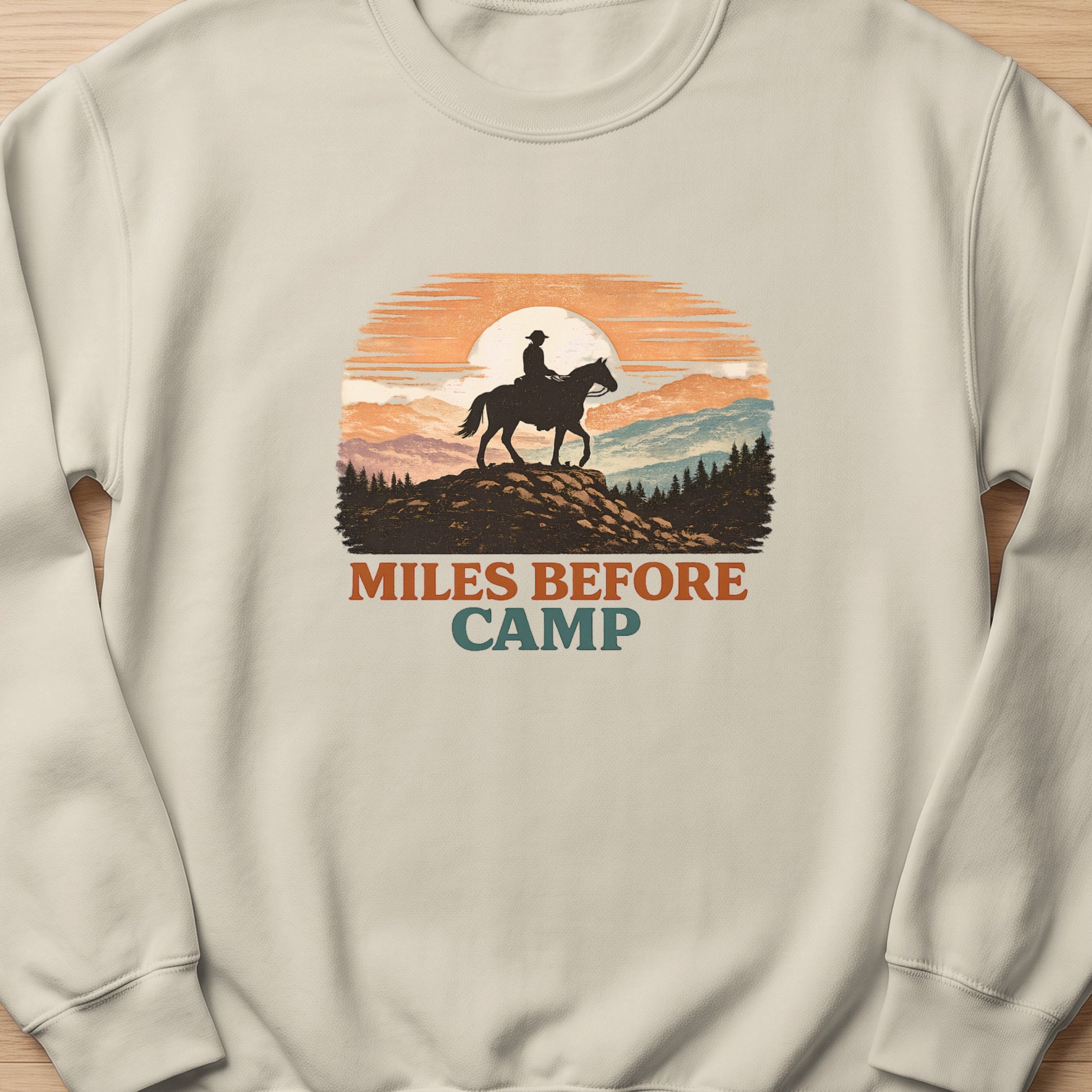 Cowboy on horseback silhouetted against a sunset with text "Miles Before Camp".