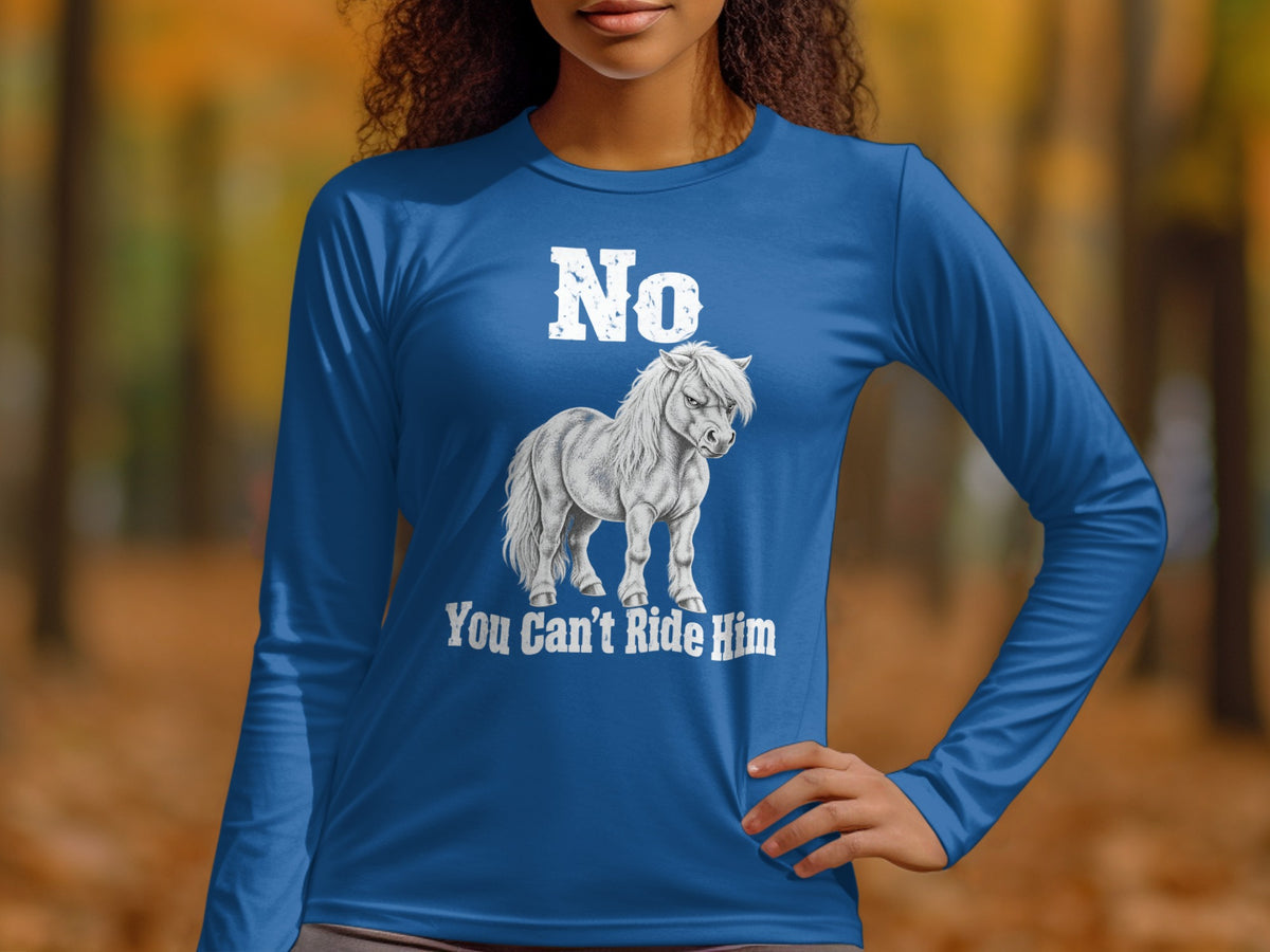 A person wearing a long-sleeved blue shirt with a grumpy pony graphic and white text saying No You Can't Ride Him.